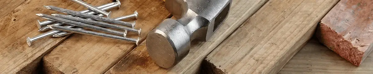 Hammer and nails on hardwood flooring boards in Dover, DE